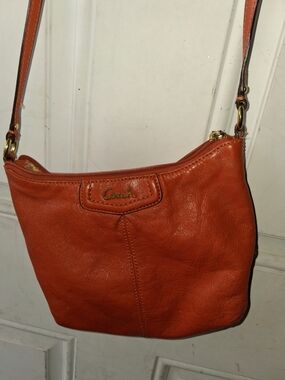 Coach Ashley Small Leather Swingpack Crossbody Bag in a persimmon orange color